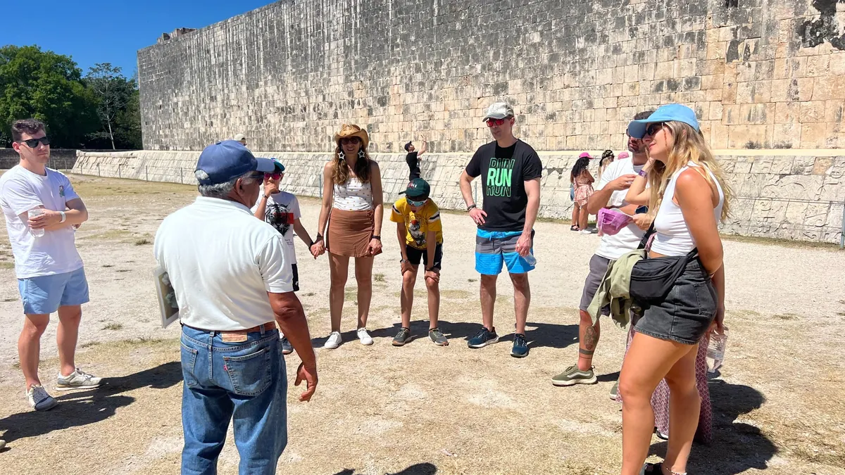 Guía de Exotik explicando la pirámide de Kukulcán a un grupo en Chichén Itzá