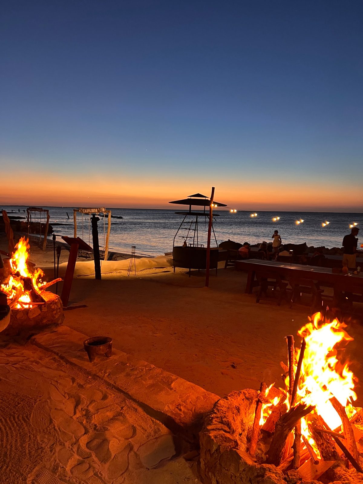 Puesta de sol con hogueras en una playa de Holbox